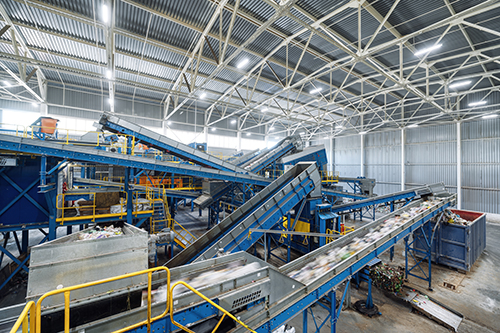 Inside a recycling center massive conveyors process collections.